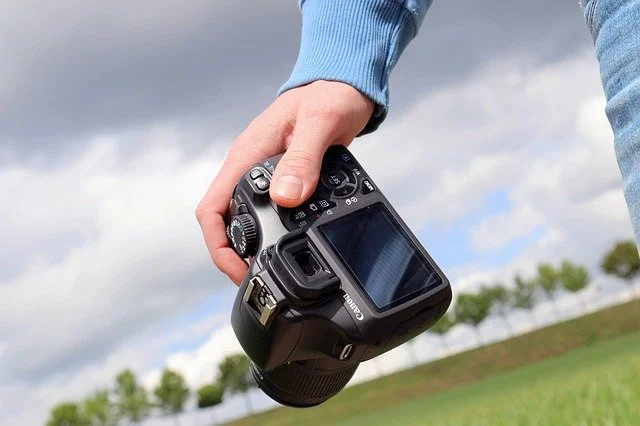 Fotoshooting Ideen - Aufnahme einer Kamera in der Hand des Fotografen